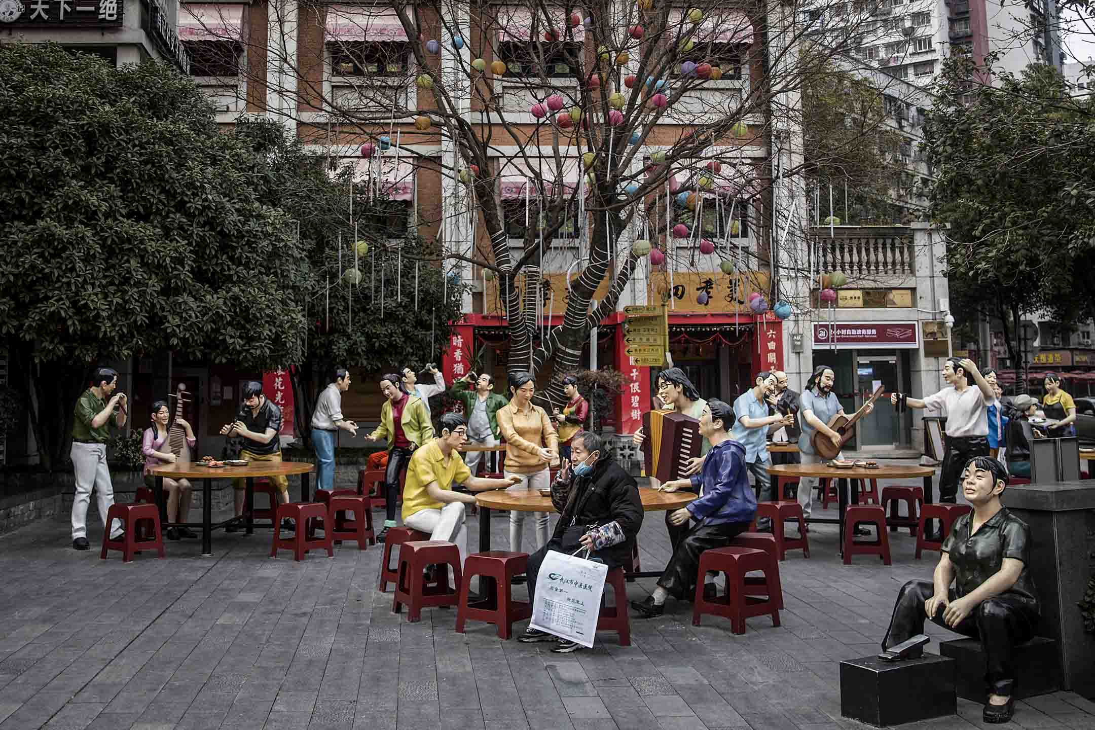 2020年2月8日,武漢一名長者坐在飲食文化街上的雕塑旁。