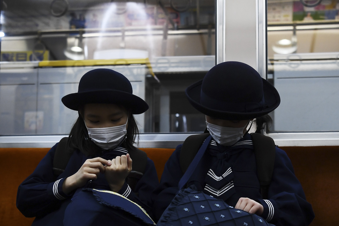 2020年2月13日，戴著口罩的女學生在東京的火車上。