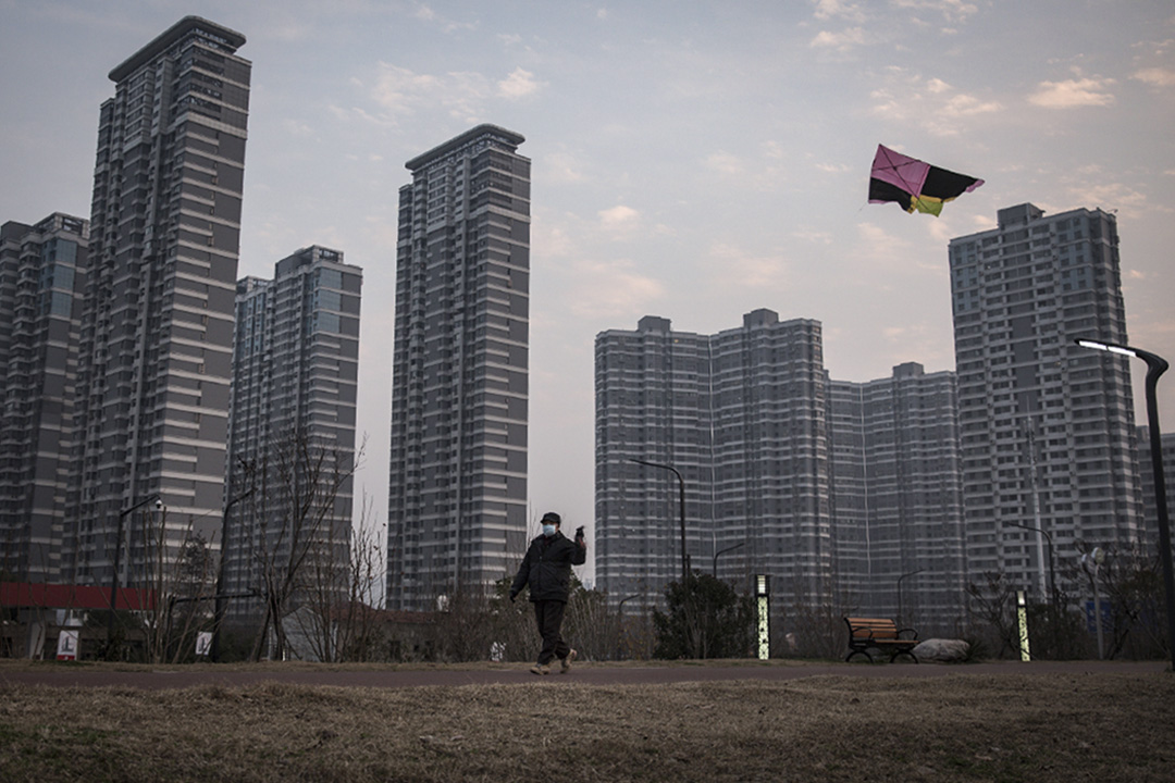 2020年2月10日,一個中國男子戴著口罩獨自一人在中國北京的辦公室大樓前放風箏。