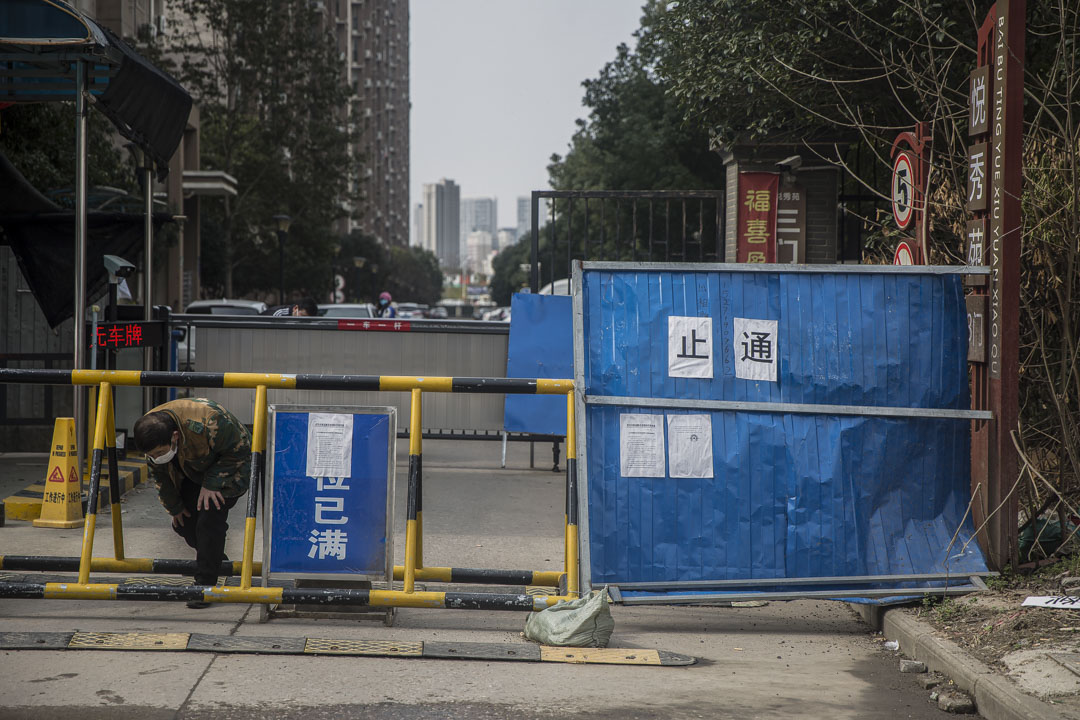 百步亭悅秀苑小區,一位快遞員把包裹放在門口後鑽出路障。