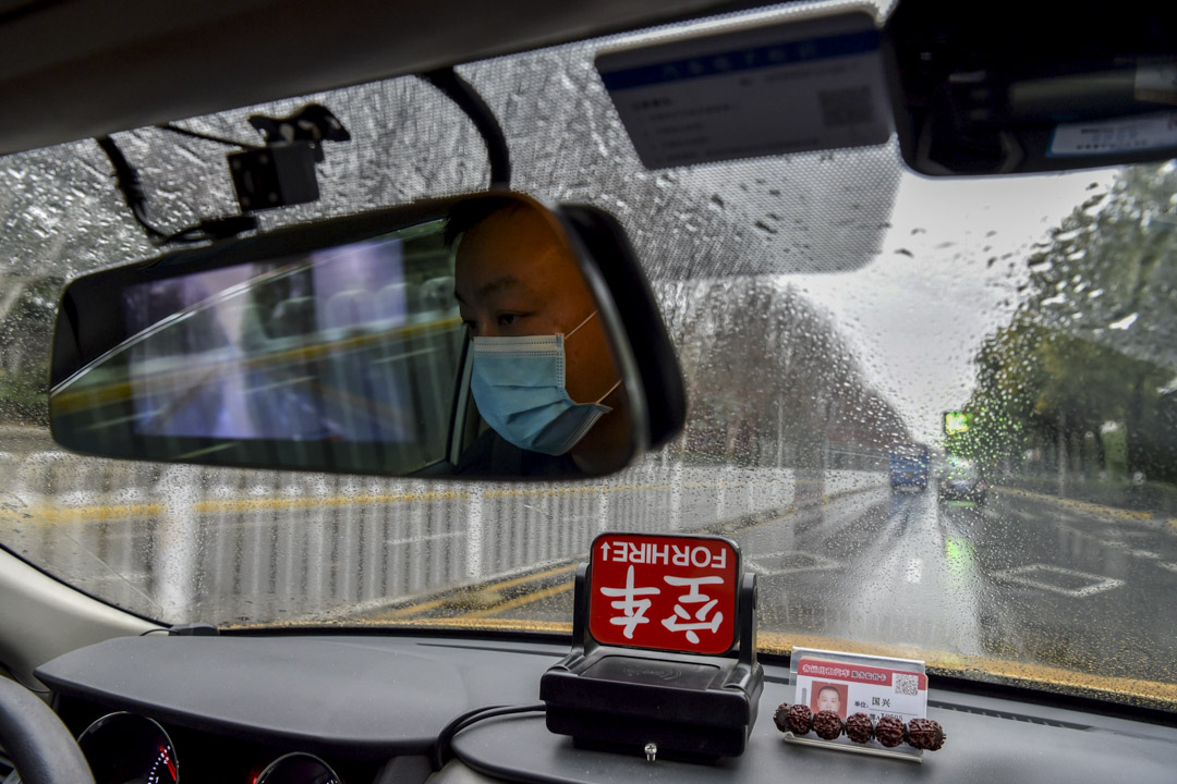 2020年1月25日，戴著口罩的士司機在武漢的街上行走。