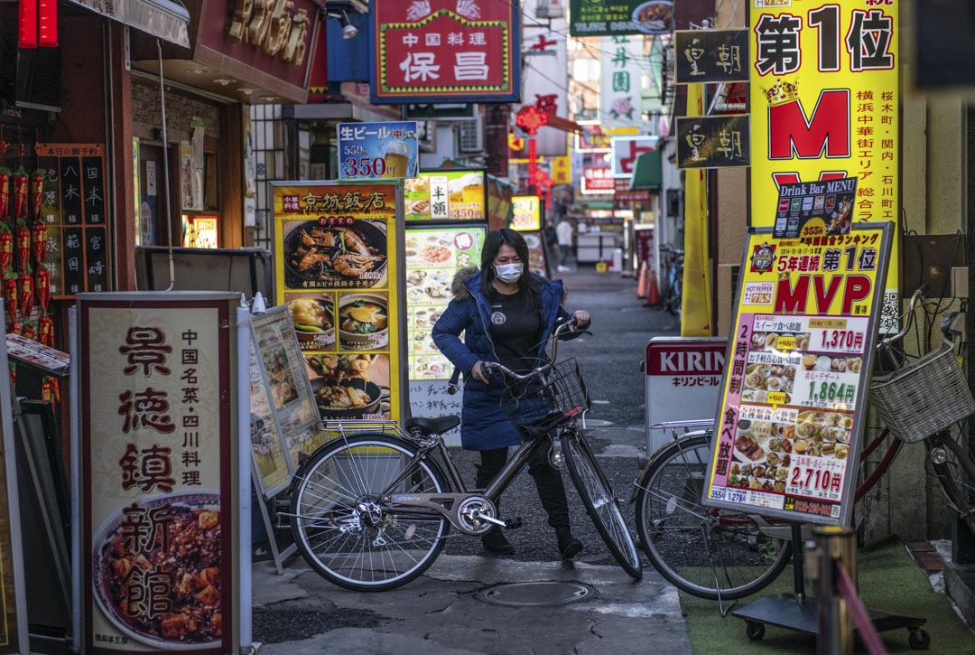 2020年2月13日,日本橫濱一位戴著口罩的女士騎單車。