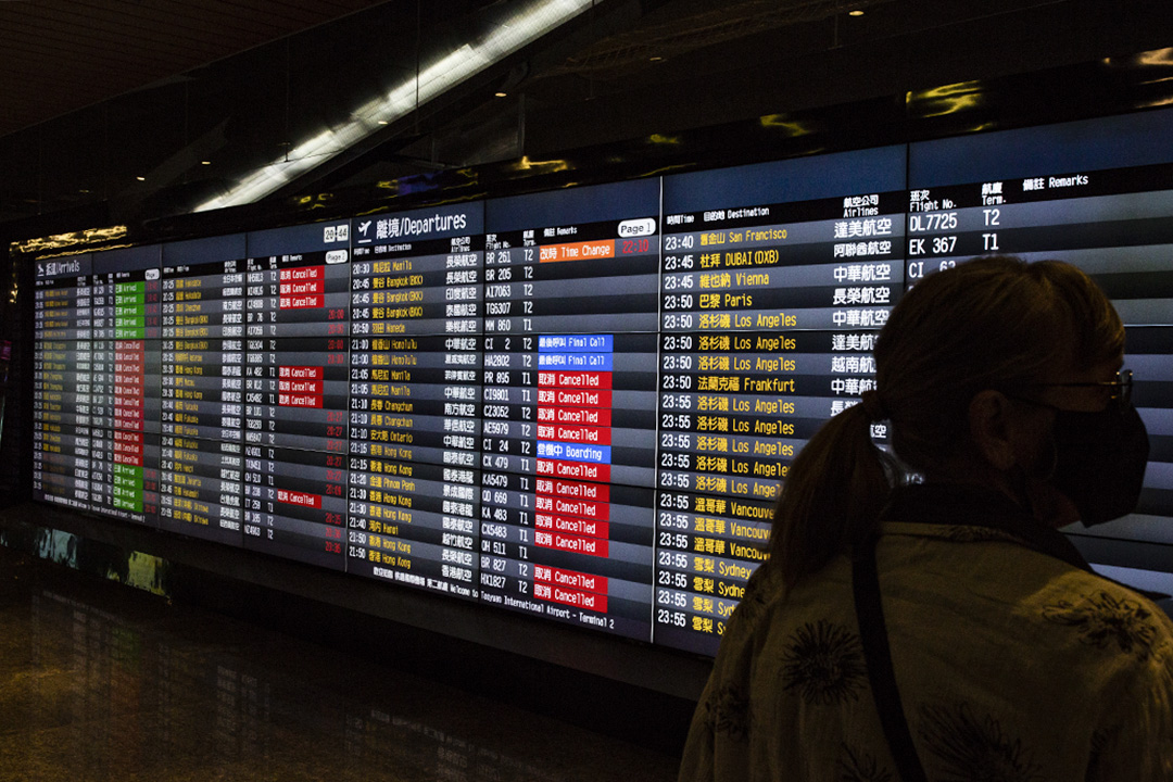 2020年2月19日，旅客在桃園國際機場的螢幕前看航班情況。