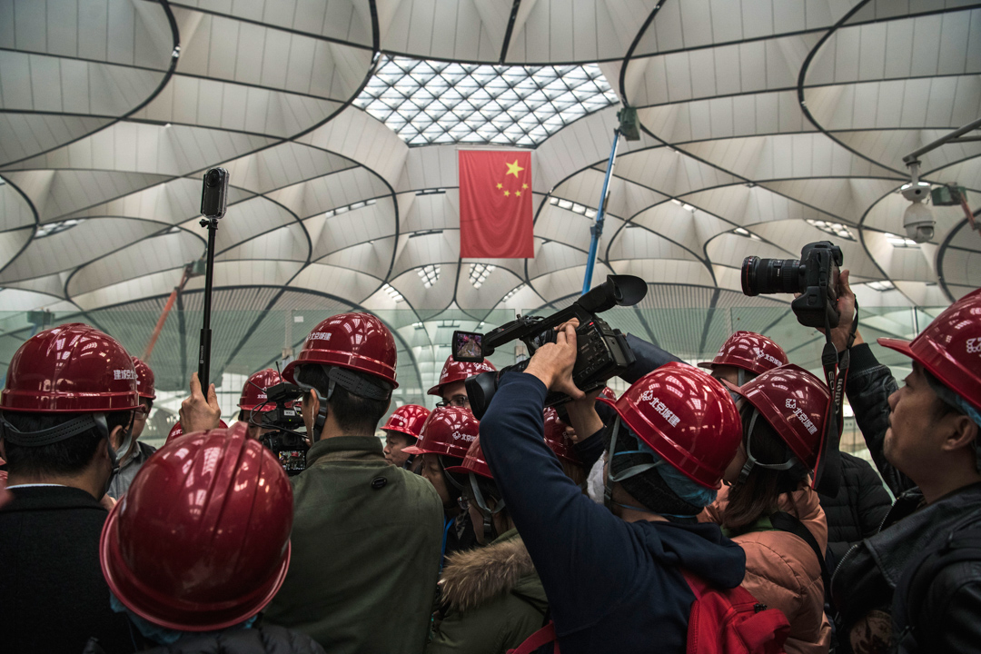 2019年3月1日,一群记者正在访问兴建中的北京大兴国际机场的一名工程师。