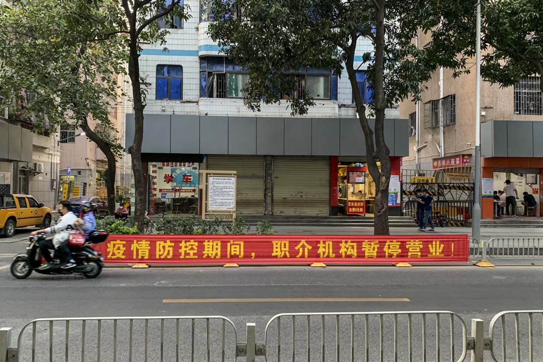 三和人才市场附近,随处可见的横幅,提醒工人这里没有工作可找。