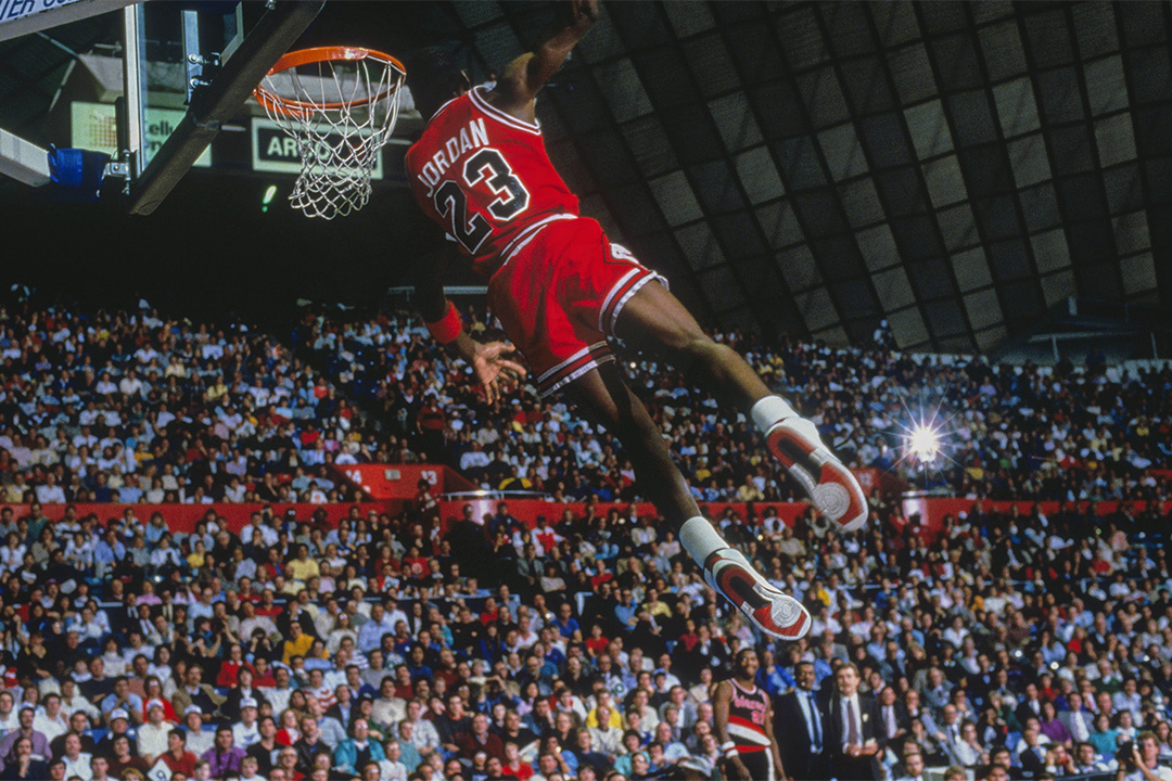 在对阵波特兰拓荒者的比赛中,芝加哥公牛队的前锋乔丹(Michael Jordan)在灌篮。