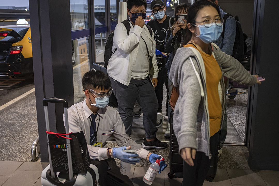 2020年3月19日,大批海外返台的民眾抵達桃園國際機場,並需消毒才可登車離開。