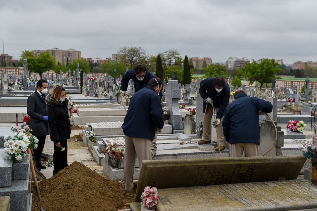 2020年4月7日,西班牙马德里一个墓地,一家人正在为他们因2019冠状病毒去世的亲人送葬。