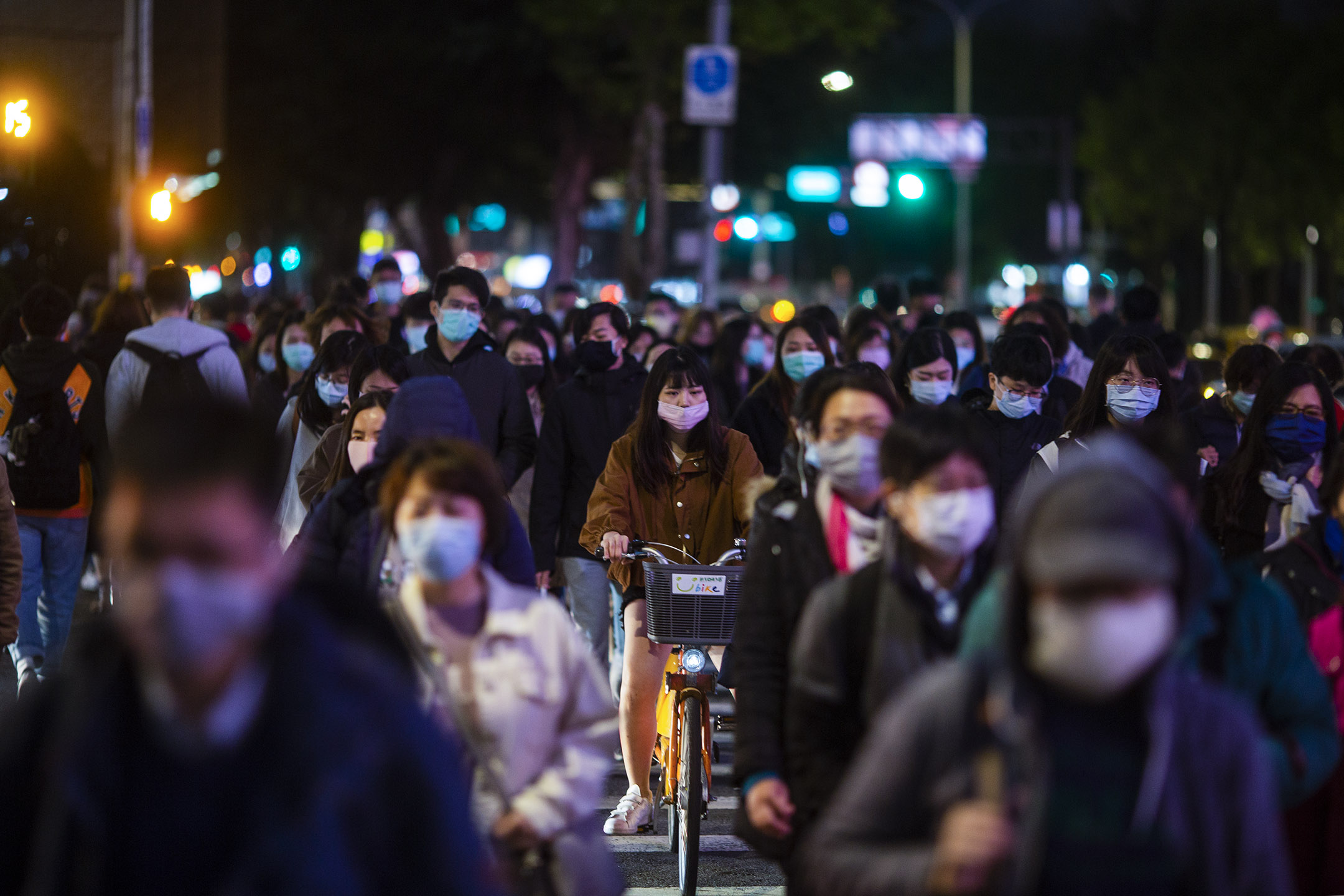 2020年4月7日,台北下班的市民戴上口罩走過馬路。