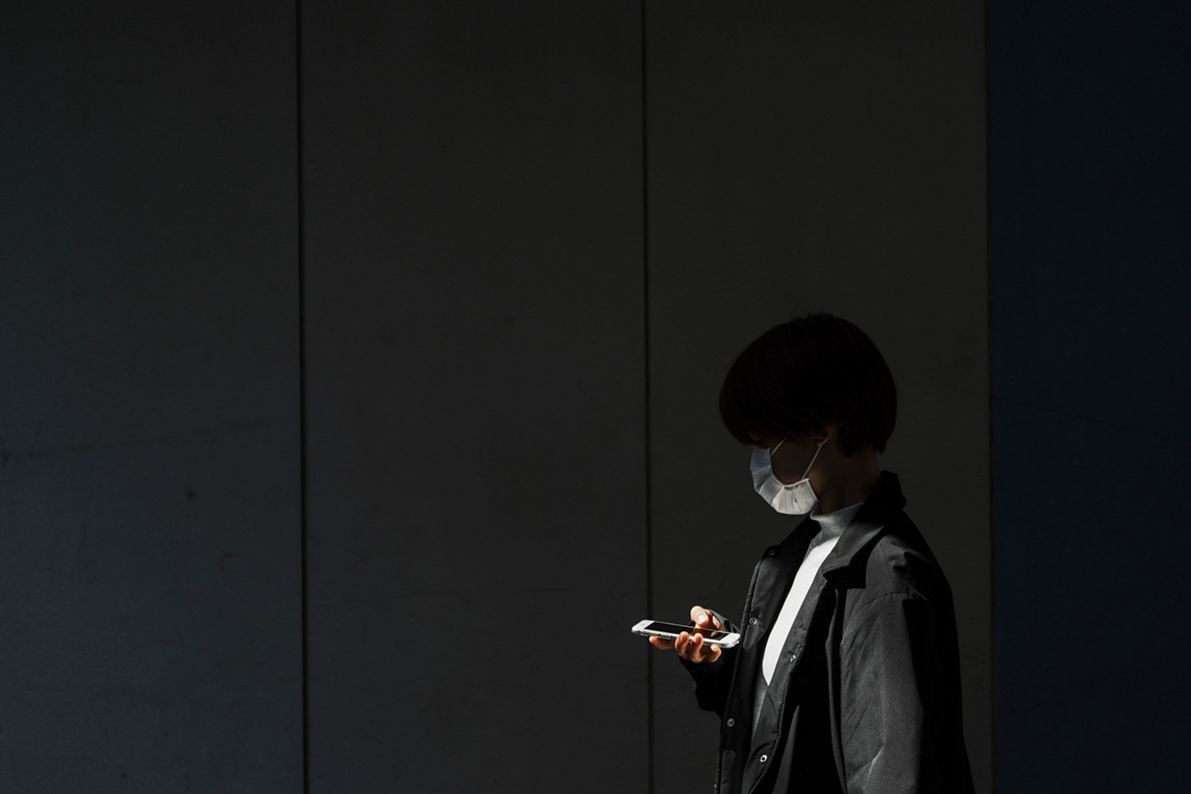 2020年4月6日,東京一名戴著防護口罩的女士走進的地下通道。