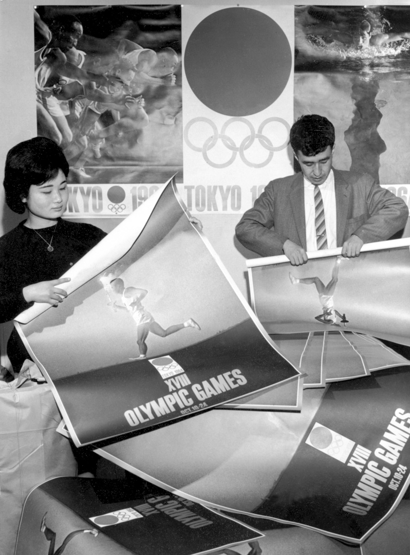 1964年5月,東京奧組委的工作人員滾動東京奧運會的海報。