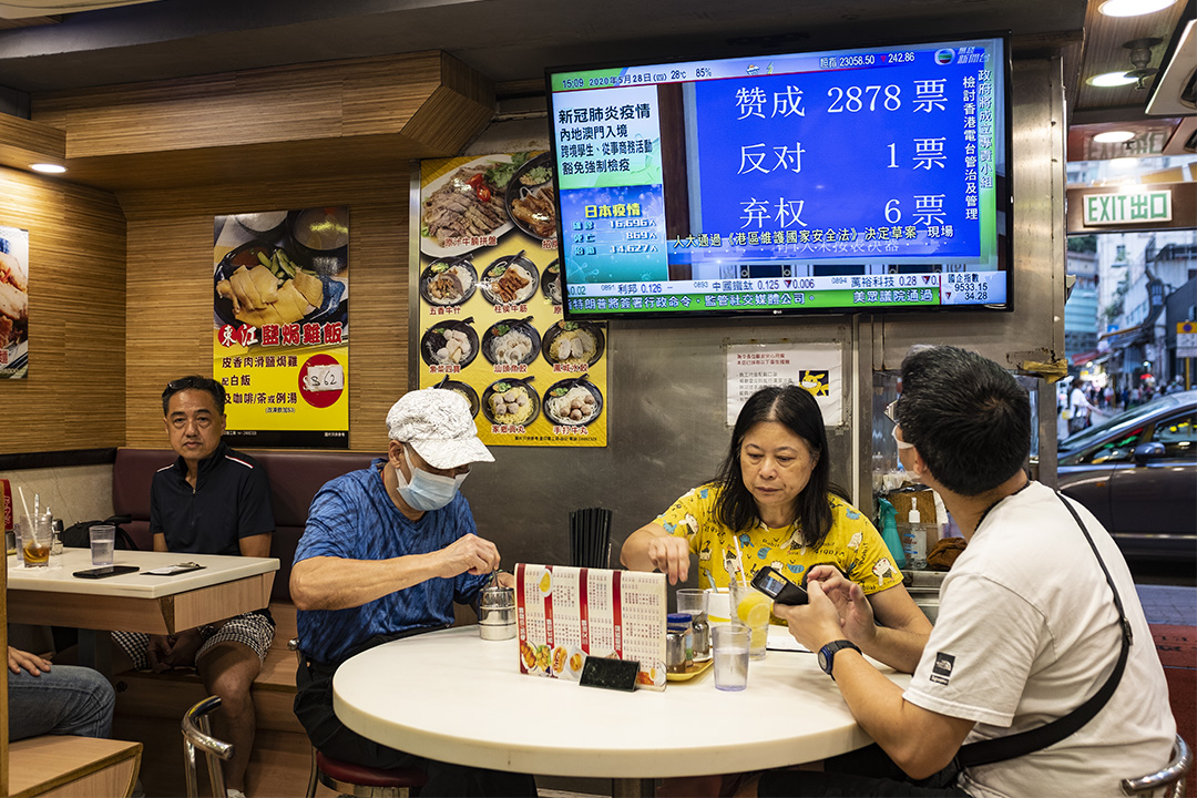 第十三屆全國人大今日下午(5月28日)閉幕,以2878票贊成、1票反對、6票棄權表決通過「港區國安法」決定草案,確定將列入《基本法》附件三,由港府公布實施。 圖爲2020年5月28日香港茶餐廳,電視上正播放人大表決新聞。