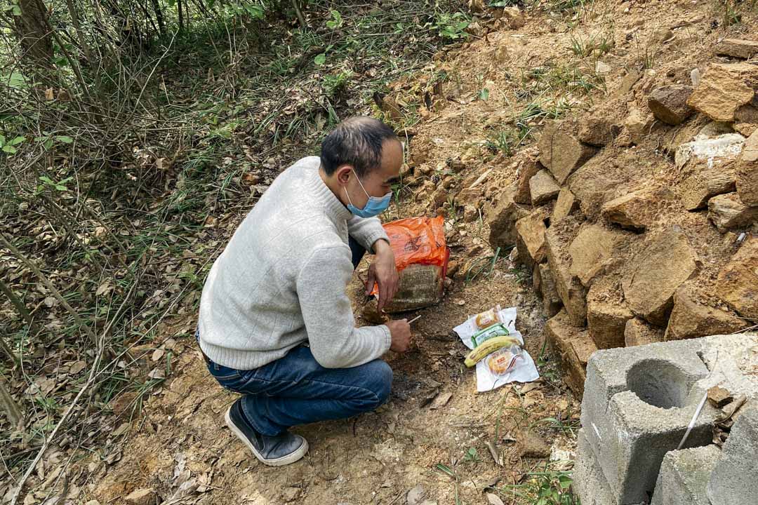 鄢小文在大儿子鄢成的墓地前拜祭。