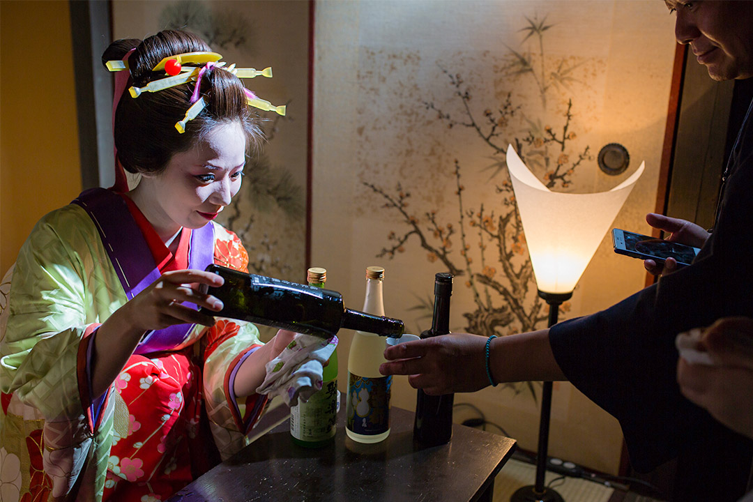 2015年5月30日京都,一名艺妓在斟酒给客人。