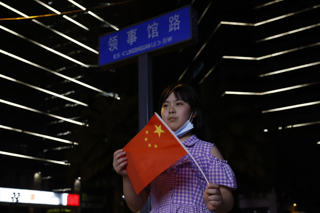 2020年7月26日,一個孩子拿著中國國旗,在美國駐成都領事館附近擺姿勢拍照。
