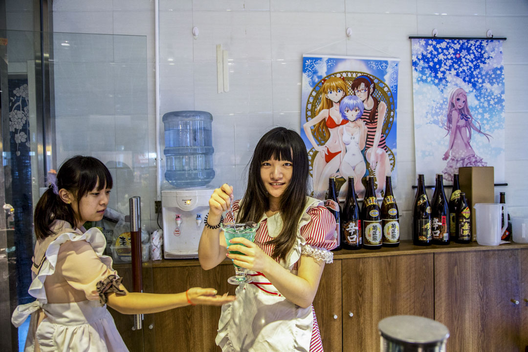 2015年8月4日,中國北京,三里屯的一家主題餐廳,兩位穿著女僕服裝的服務員為顧客調製飲料。