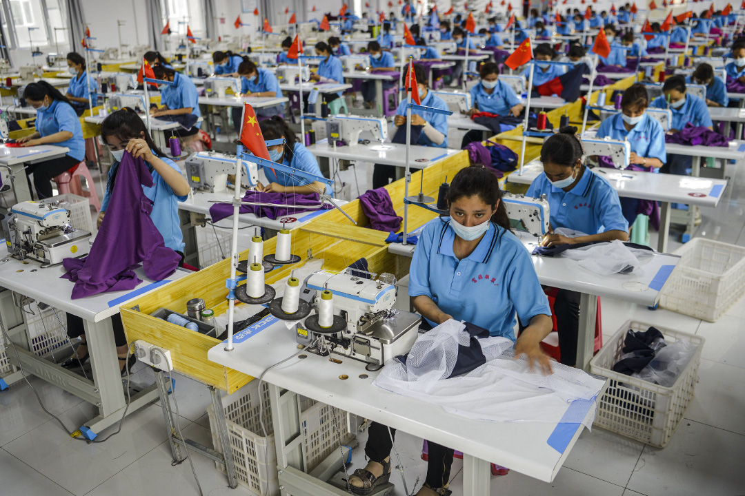 2020年6月18日中國新疆維吾爾自治區,工人戴着口罩在一家服裝廠工作。