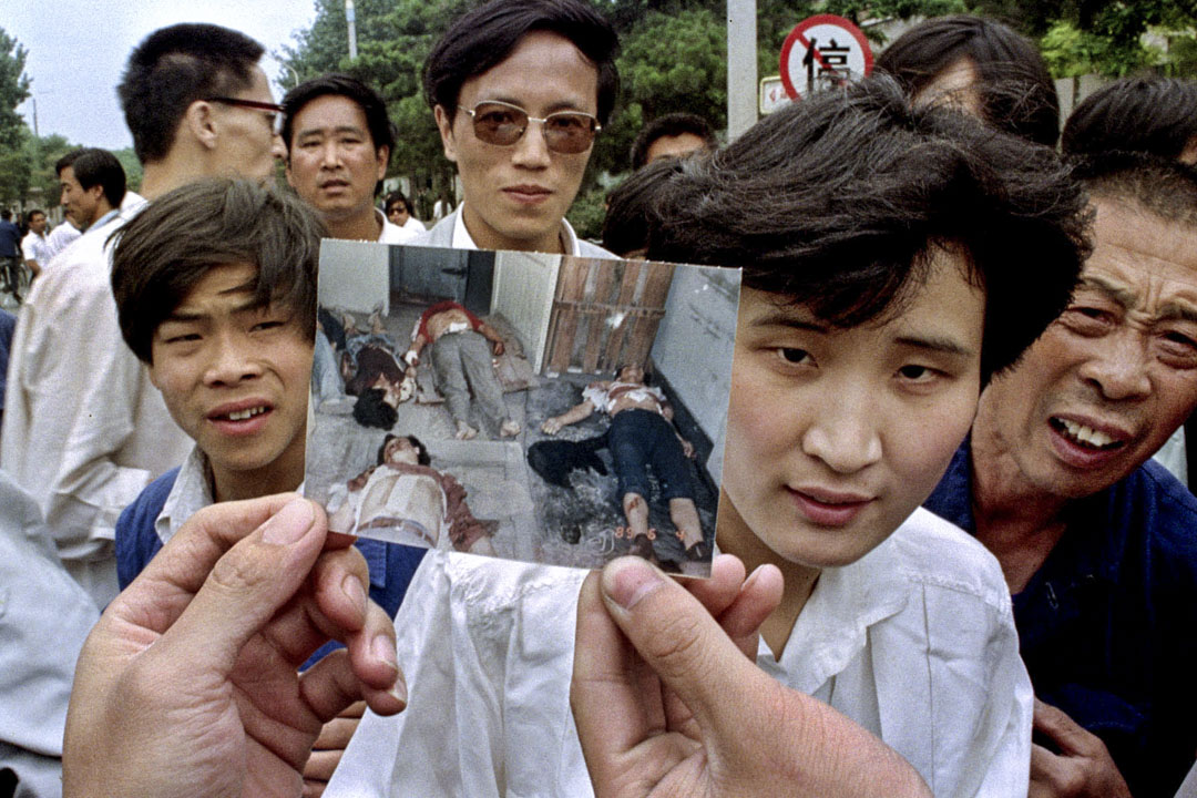 1989年6月5日北京,人們舉著一張照片稱他們是天安門廣場上被鎮壓的死難者。