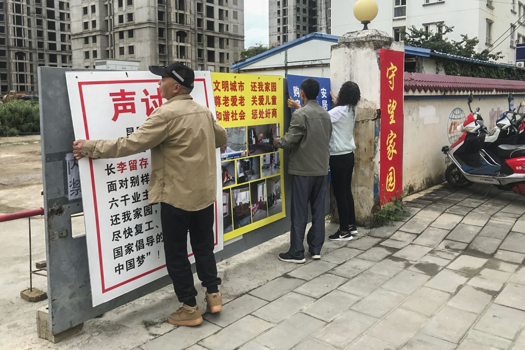 业主们每天一大早会把三幅声讨开发商的广告牌挂在大门口,晚上再收回去。此前,他们贴在大门上的广告纸曾被开发商所属物业公司涂抹销毁。所以他们才想出这个办法。