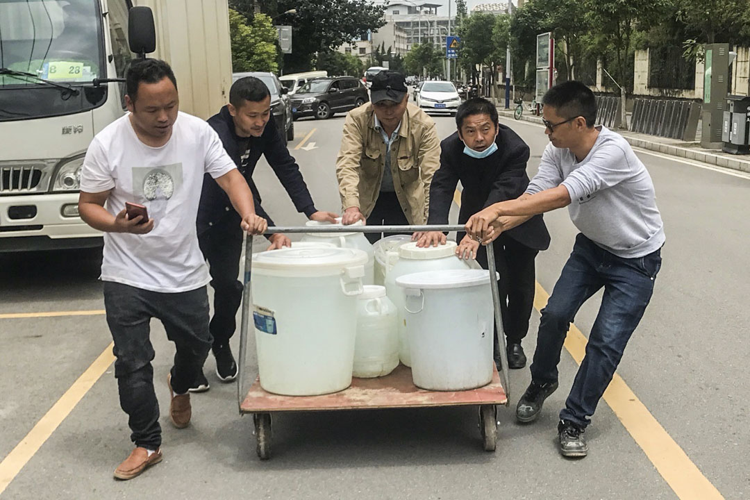 烂尾楼里的男人们每天都要去附近100米的美容院接自来水,供50多户业主做饭、喝水。