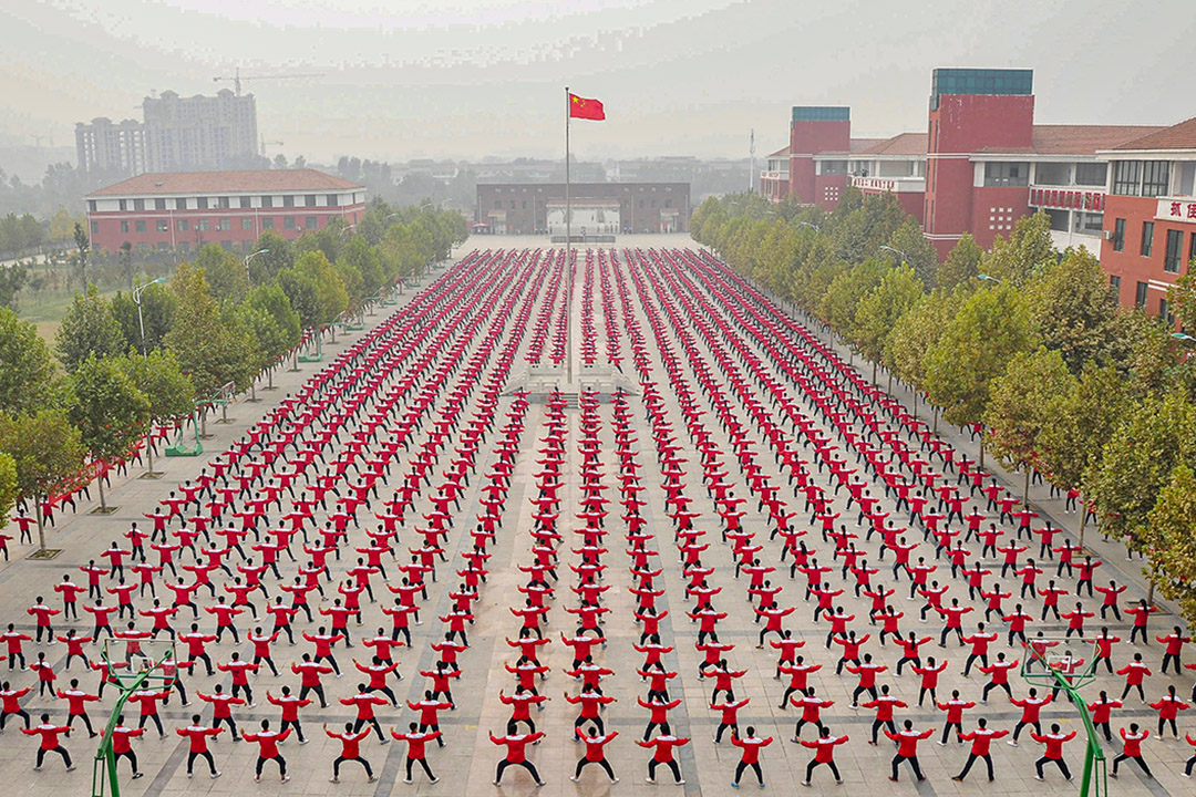 2015年10月18日中国河南省,中国国旗下学生们在高中的操场上练习太极拳。