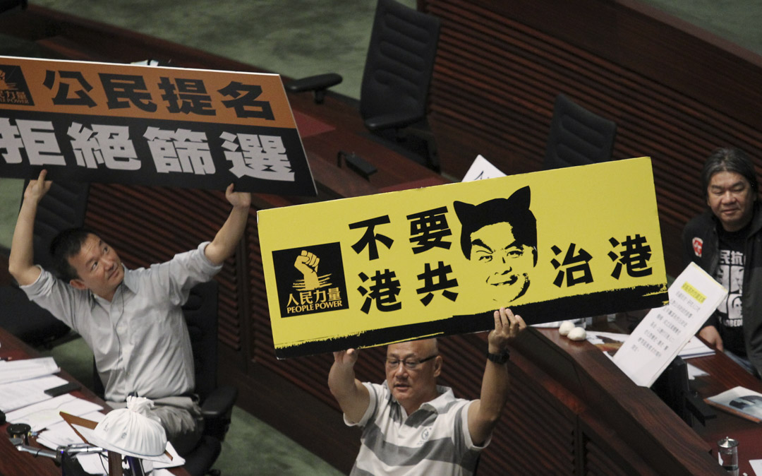 2014年5月22日,陈志全、陈伟业与梁国雄在立法会高举标语抗议。