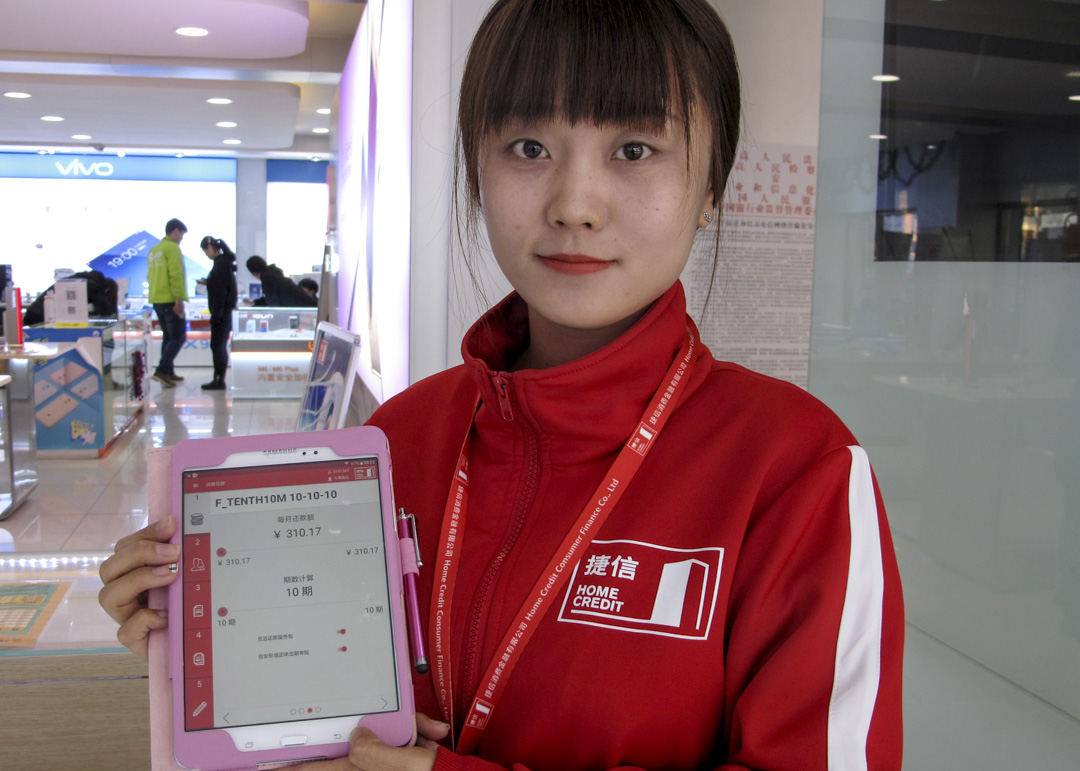 一名工作人員展示捷信集團旗下的「捷信消費金融」應用程式。