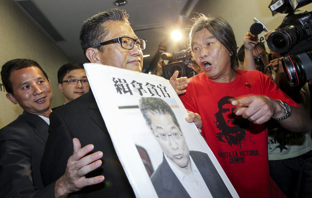 2013年7月25日,立法会议员梁国雄在立法会发展事务特别会议上向发展局局长陈茂波抗议。
