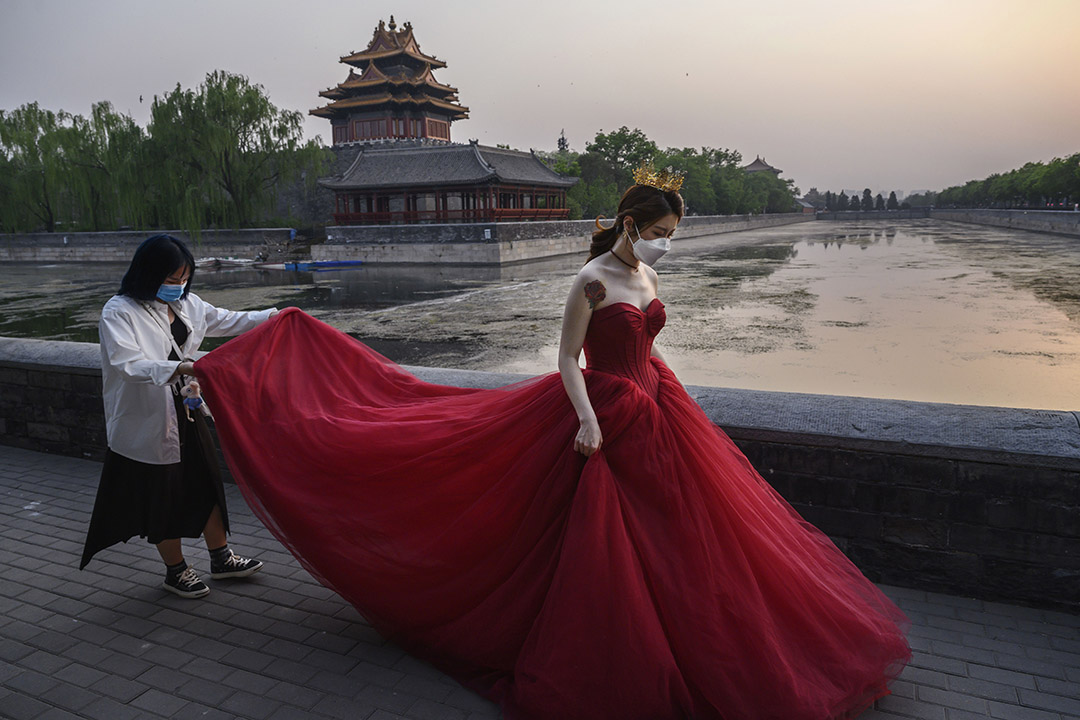 2020年4月30日北京,一名中国妇女戴著口罩在北京紫禁城外拍婚纱照。