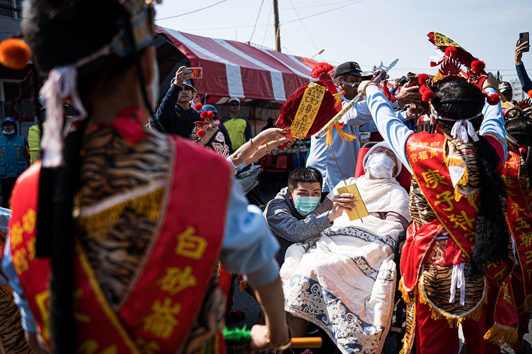 一名病重的妇女,被亲友带到祭典现场,盼望能获神明庇佑、得以康复。