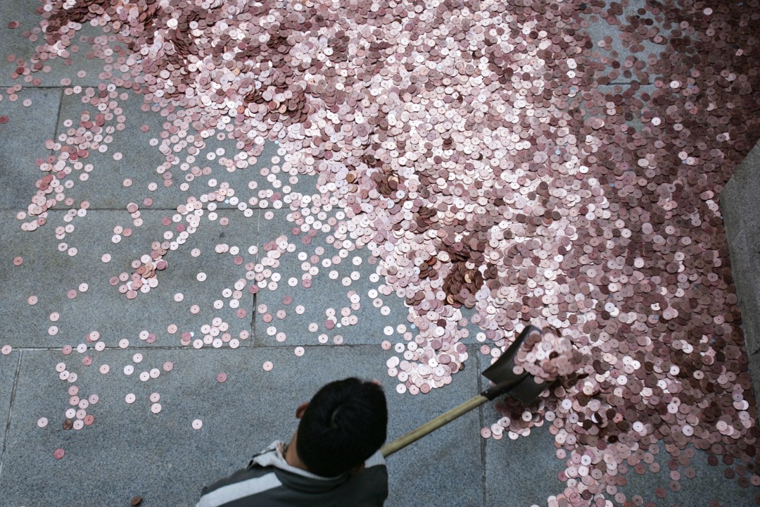 2007年,北京,白云观的一位员工在清理市民为祈福抛出的硬币。