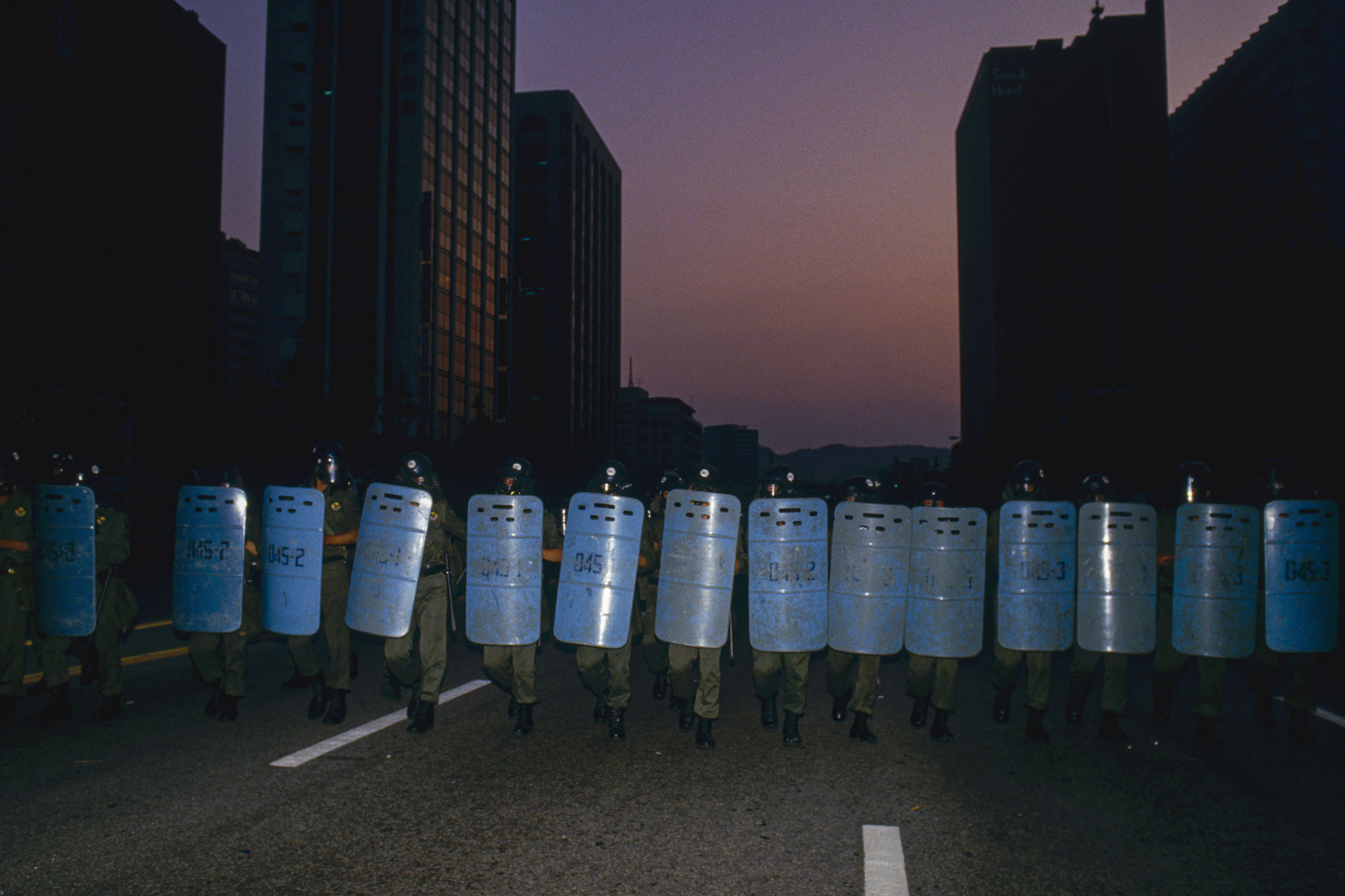 1987年6月26日,一次学生示威游行中,韩国防暴警察走在汉城的街道上。