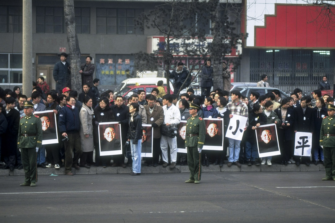 1997年2月24日,哀悼者拥挤在长安大街,并举著他的肖像,向已故领导人邓小平致敬。
