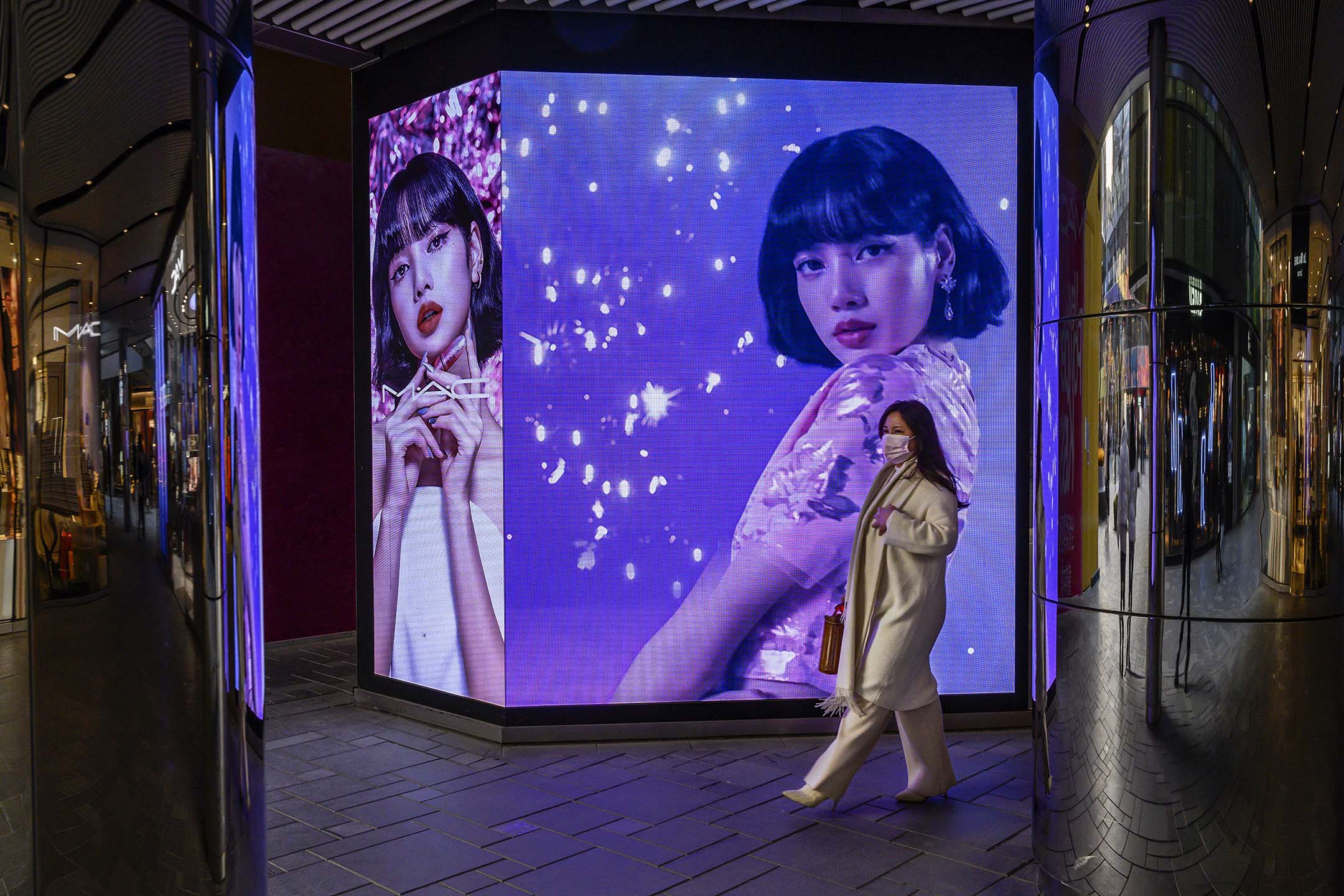 2020年12月9日北京,妇女走过一个化妆品公司的广告。