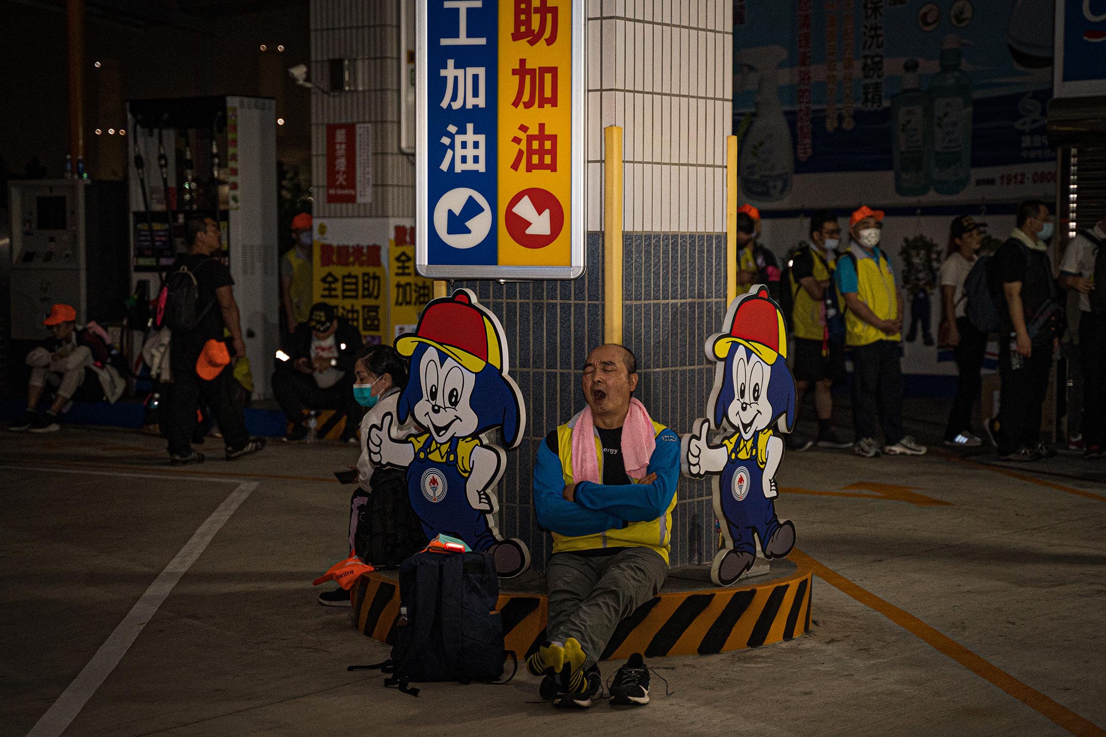 在少有民宅的公路路段上，加油站是信眾如廁、補給、休息的重要據點。一名信眾在加油站就地休息。
