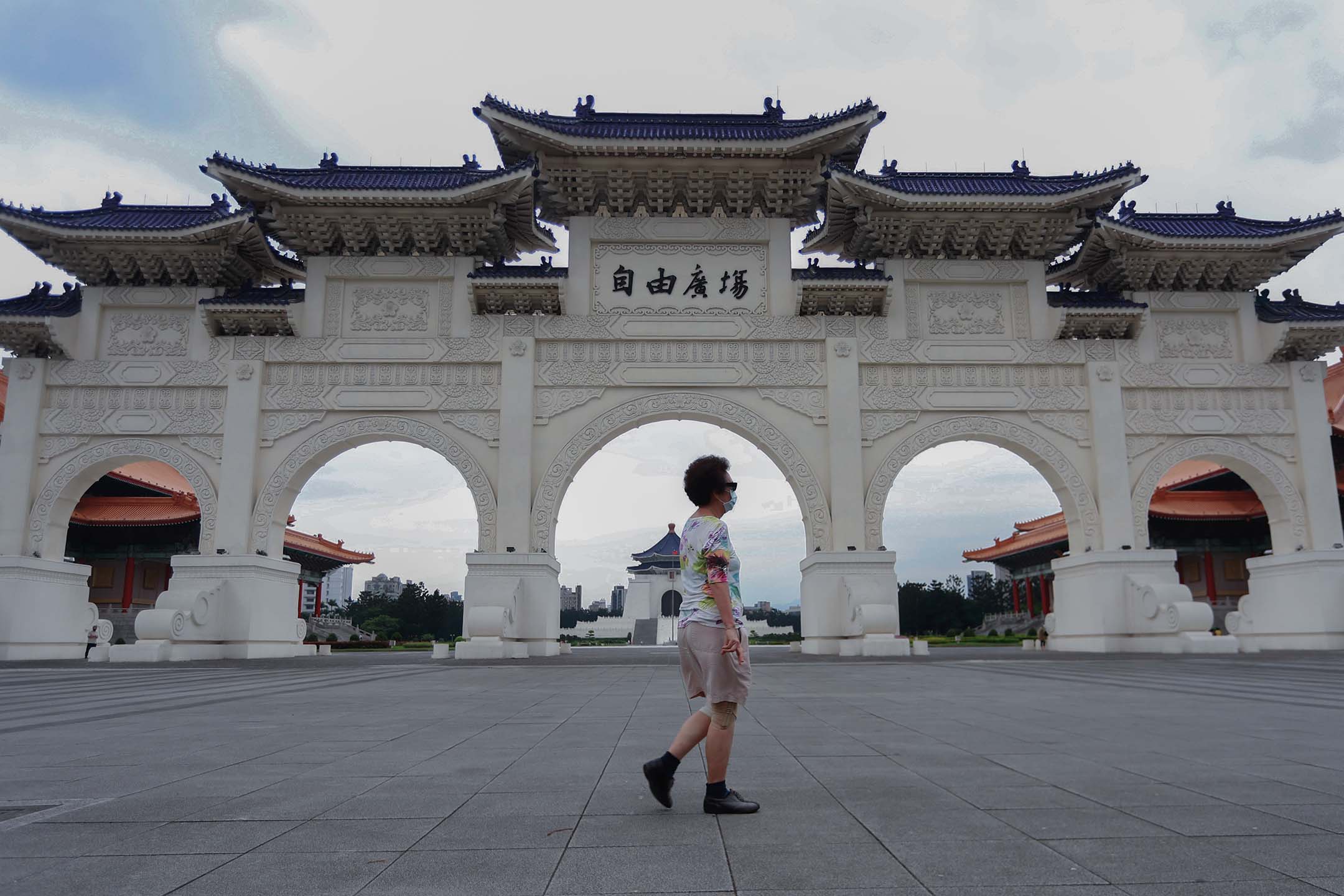 2021年5月21日台灣台北,2019冠狀病毒病例激增之後,戴著口罩的人們走過自由廣場。