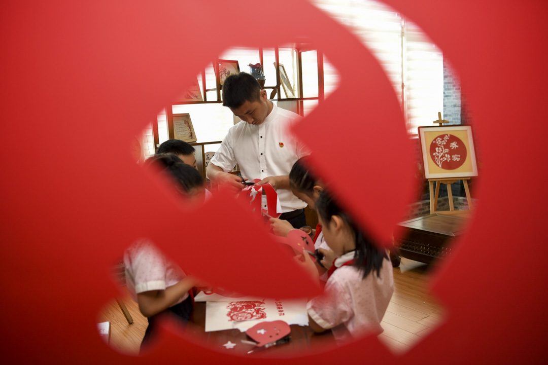 2020年6月30日,中國貴陽,慶祝中國共產黨成立99週年,一間小學教師指導學生手工剪紙。