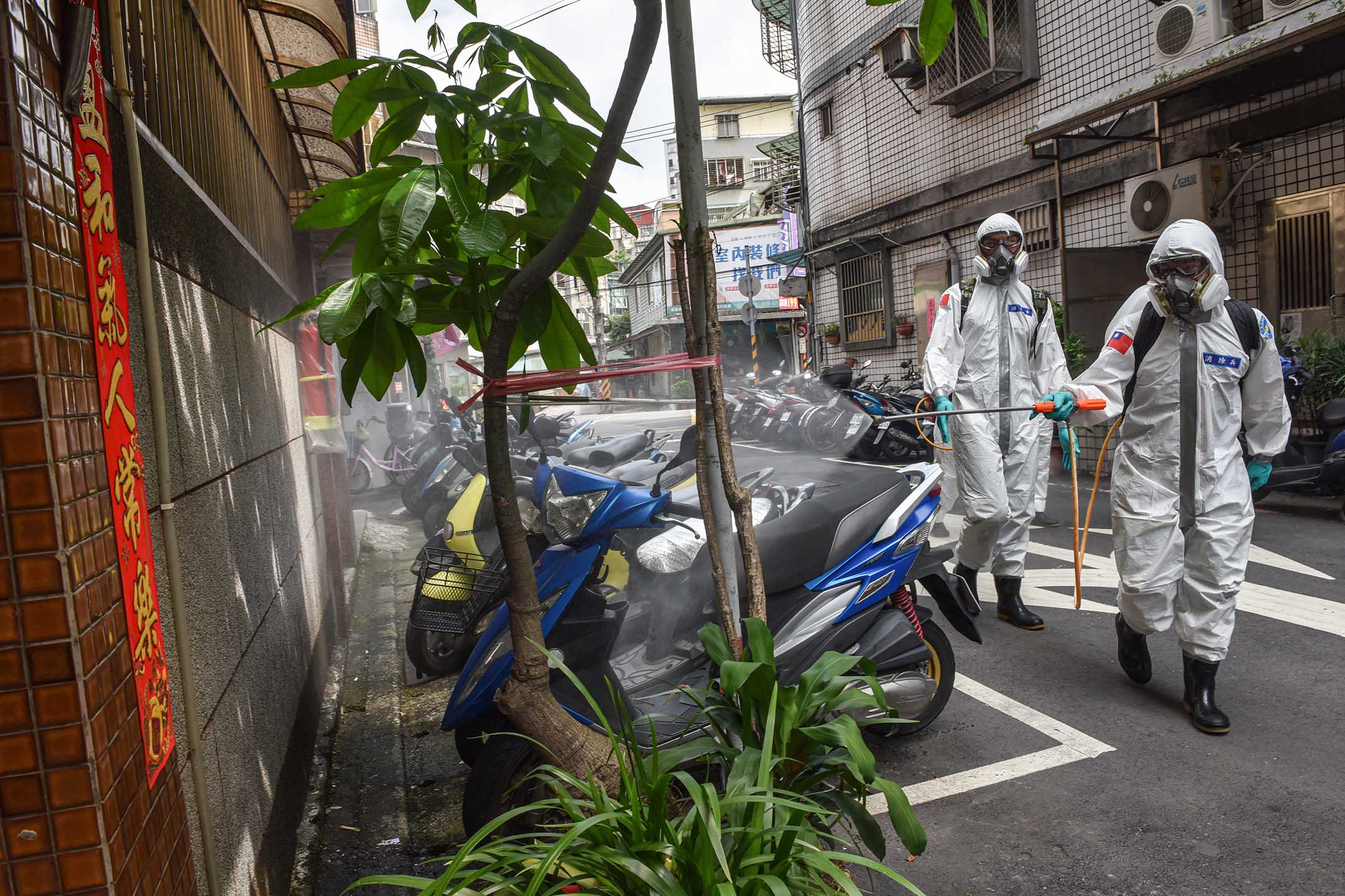 2021年5月26日台灣台北,身穿防護服的軍人在街道上消毒。