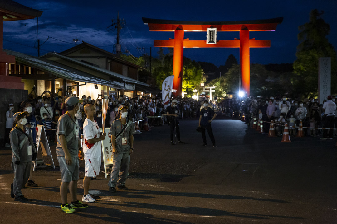 2021年6月25日,日本富士宮舉行的東京奧運會火炬傳遞期間,一名火炬手在接力點等待。
