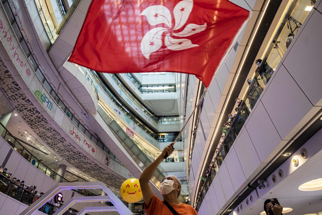 2021年7月30日,大批市民到觀塘apm商場觀看賽事,現場有橙色衫的男子在場揮舞香港區旗。