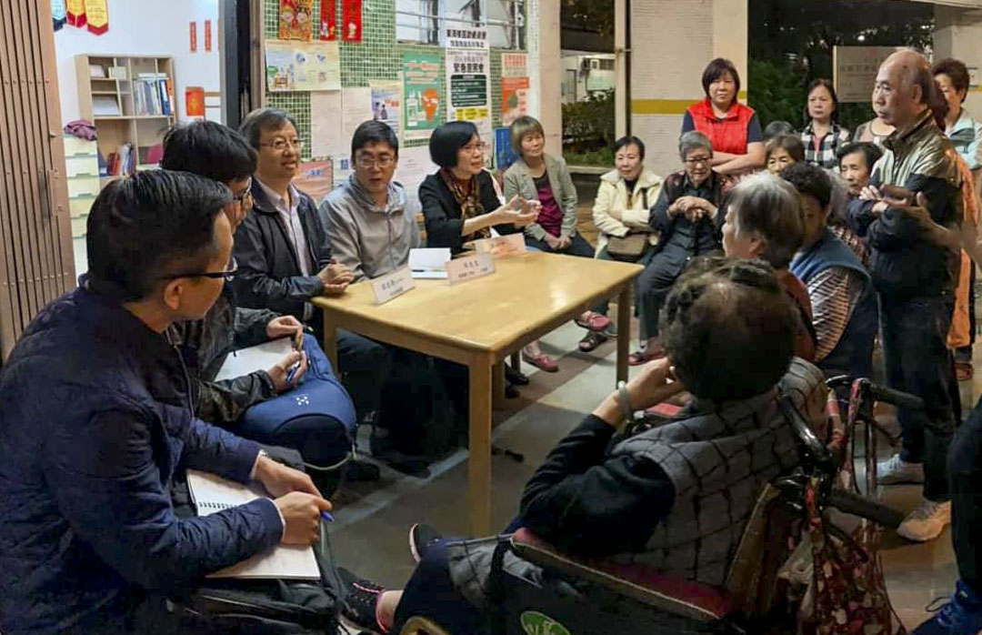 譚國僑於與街坊、房屋署工程師等人討論工程事宜。