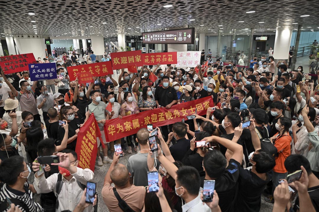 2021年9月25日,深圳人們在深圳寶安國際機場等待孟晚舟回國,舉著寫有「歡迎回家孟晚舟」的橫幅和標語牌。