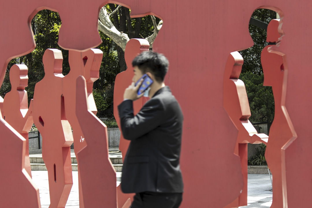 2021年4月10日,上海一名市民走过城中的一座雕像。