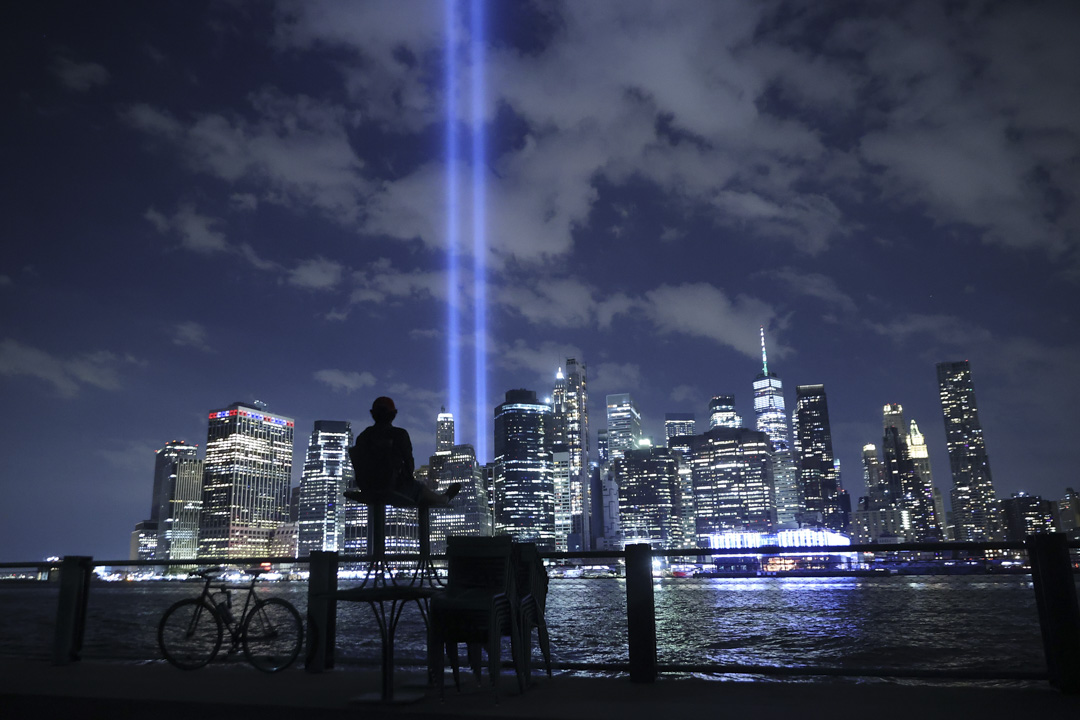 2021年9月7日,为纪念911 事件的受害者,光之致敬是一个纪念性公共艺术装置,纽约一位市民观看从曼哈顿下城射入天空的光。