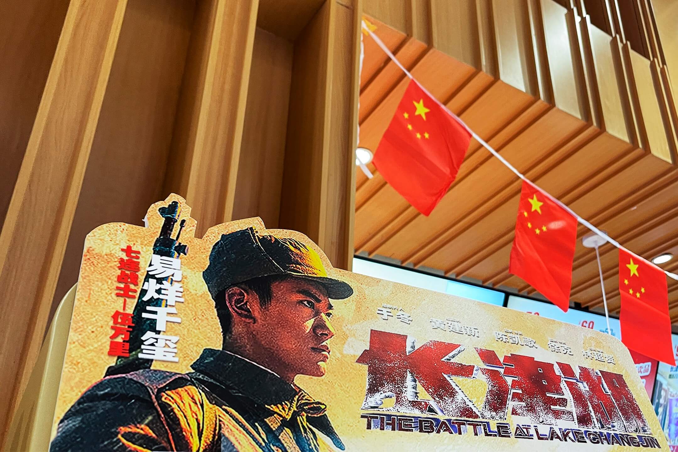 2021年9月30日,中国首都北京一家戏院门外,摆放著《长津湖》的电影海报,门口悬挂著国旗装饰迎接国庆。