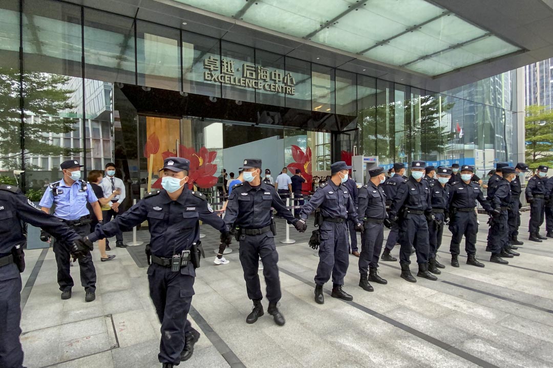 2021年9月13日,深圳恆大總部外的保安在大廈外築起人鏈,抵擋那些要求償還貸款和金融產品的市民。