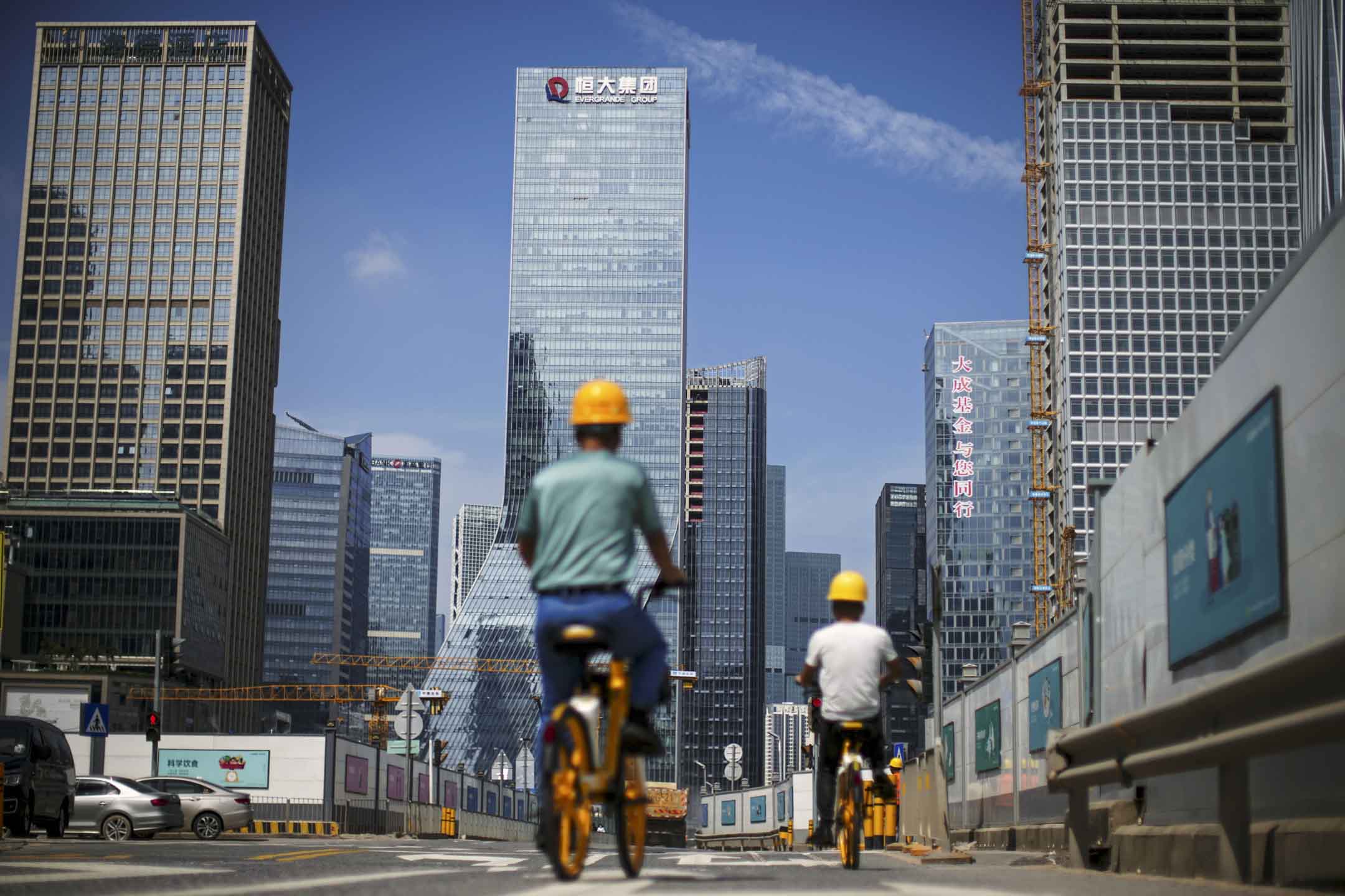 2021年9月26日,男子騎單車經過深圳市恆大集團總部附近的建築工地。