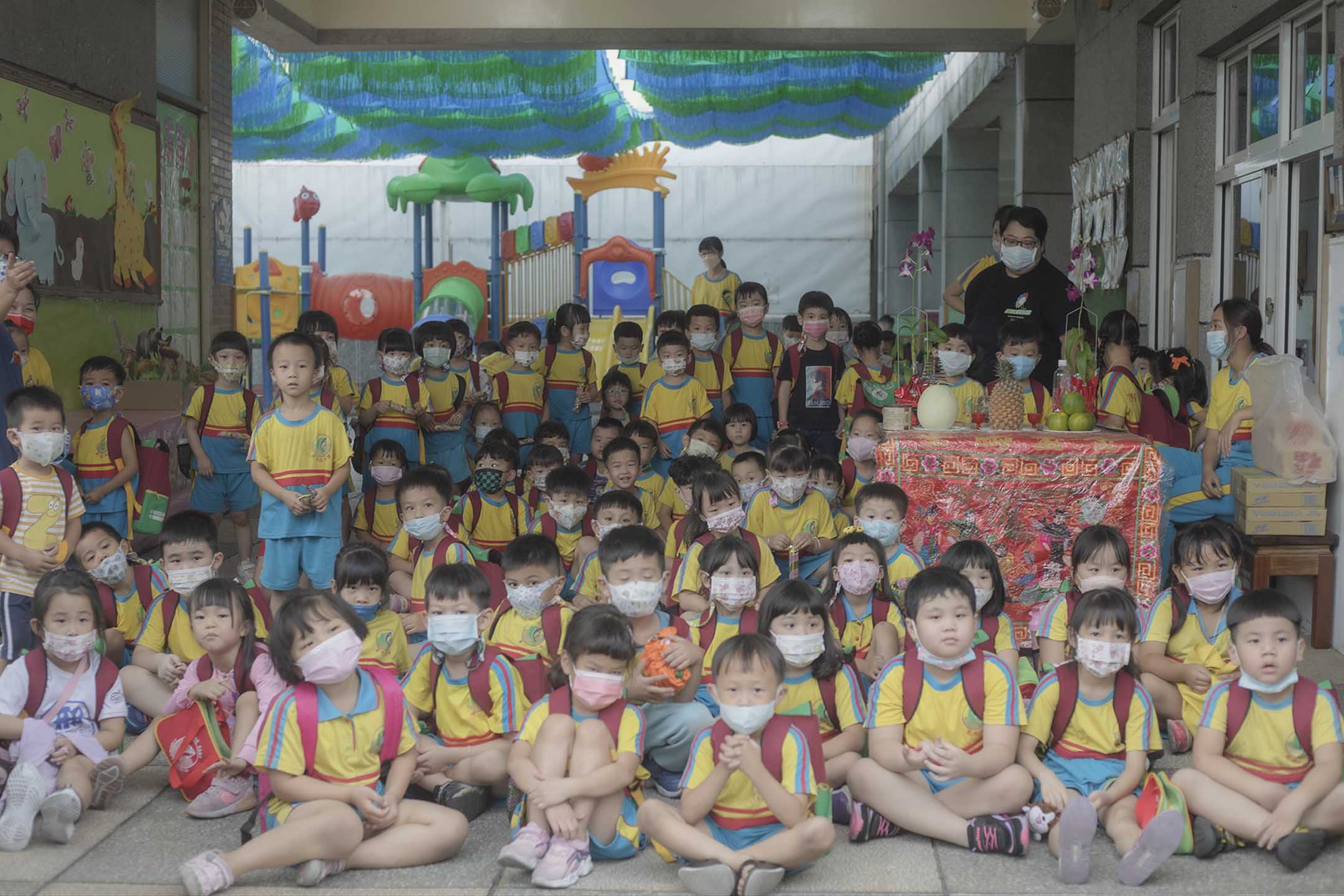 2021年10月25日东港,幼儿园学生等待放学,学校门前放上祭品。