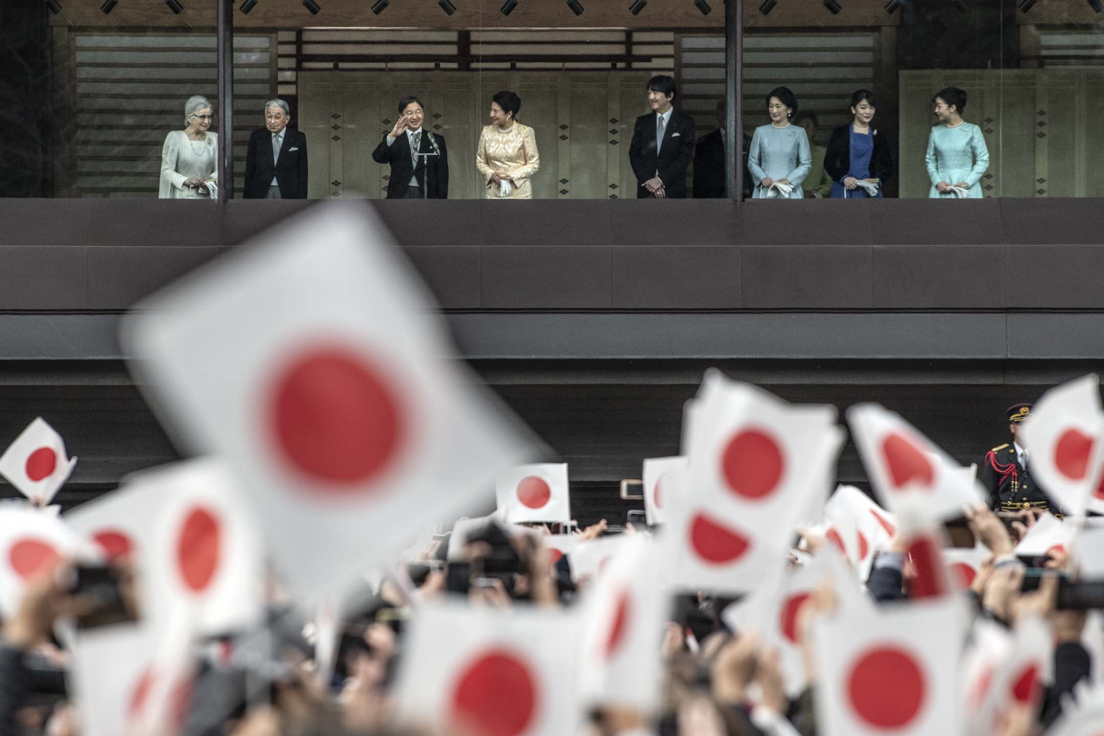 2020年1月2日,日本德仁天皇与皇室人员在东京皇居致以传统新年问候后,祝福者挥舞旗帜。