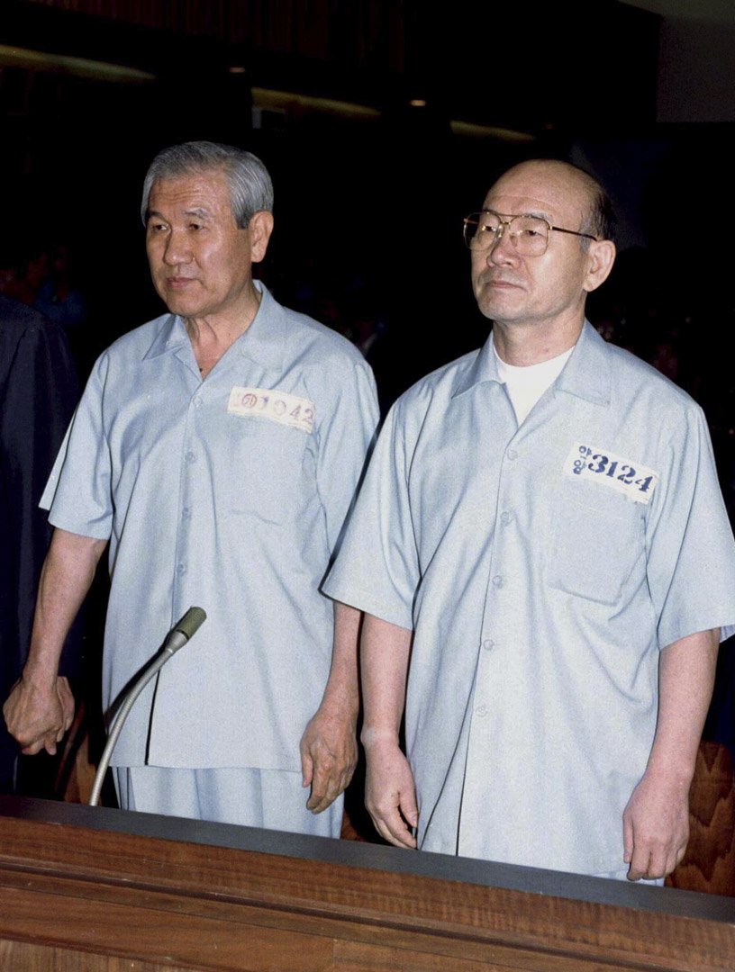 1996年8月26日,身著監獄制服的南韓前總統全斗煥(右)和盧泰愚(左)在首爾刑事法院。